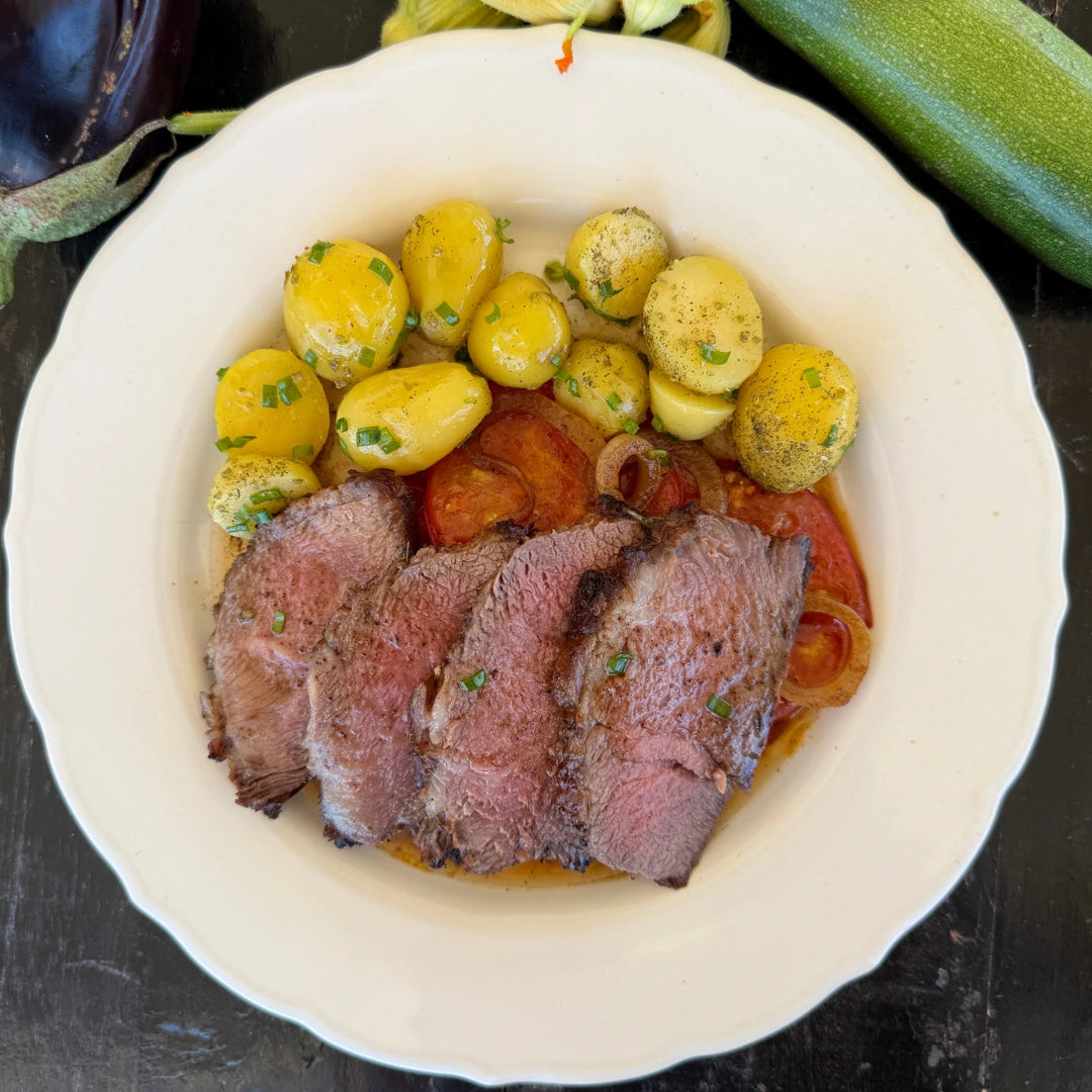Black Iberian pork presa, baby potatoes, and grilled tomato