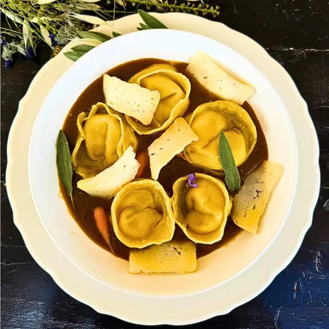 Tortellini with ricotta cheese, herbs, roasted vegetable sauce, and cheese.