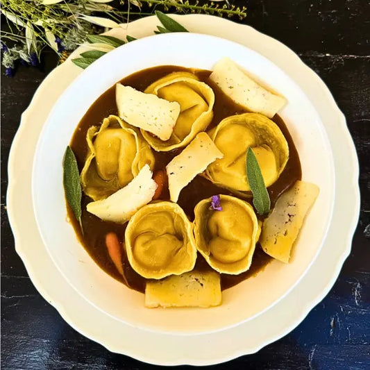 Tortellini with ricotta cheese, herbs, roasted vegetable sauce, and cheese.